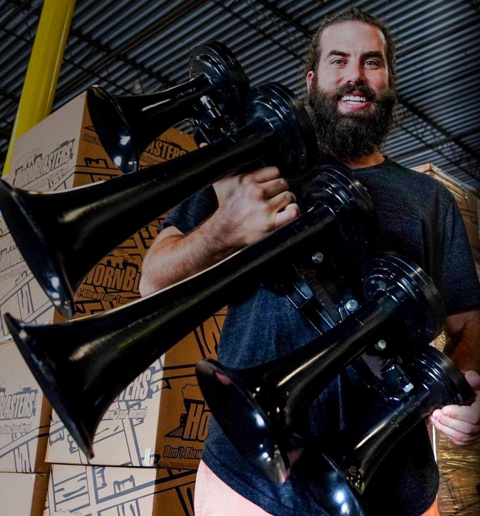 Matt Heller on a walkway above the HornBlasters warehouse floor, pallets of stock behind him.