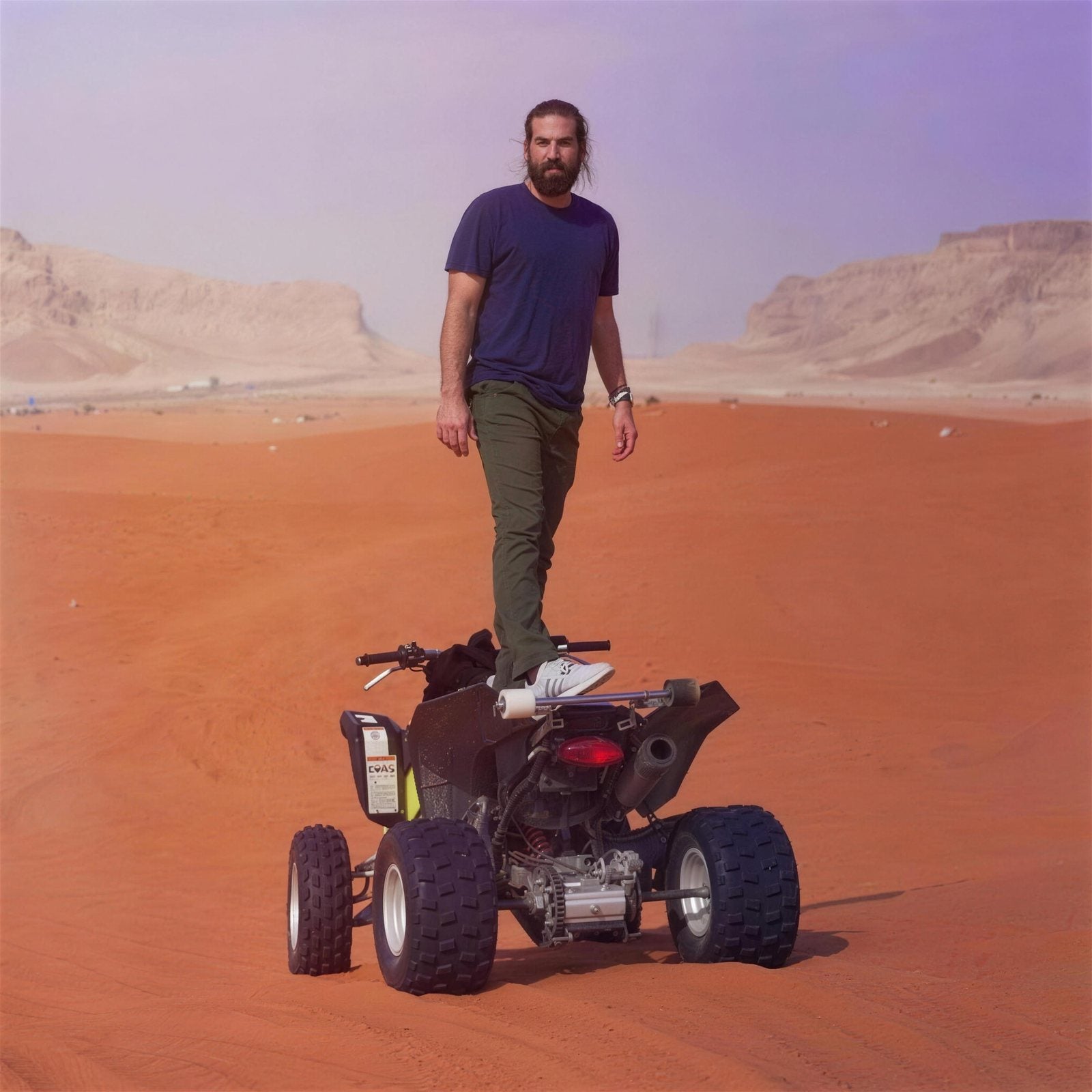 Matt Heller on a quad in open sand dunes.